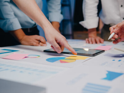 Millennial Asia businessmen and businesswomen meeting brainstorming ideas about new paperwork project colleagues working together planning success strategy enjoy teamwork in small modern night office.